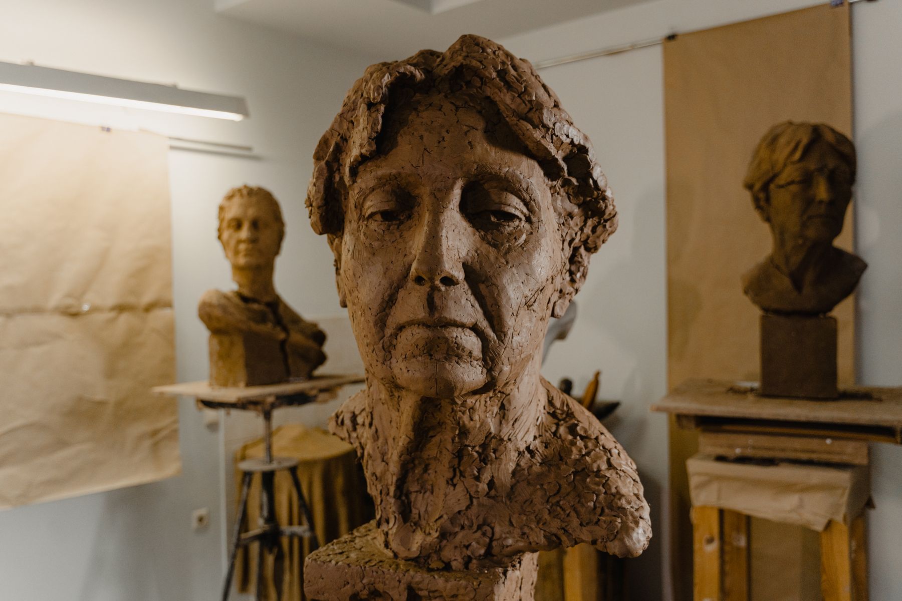 Expressive hand-modelled clay portrait bust in an art studio
